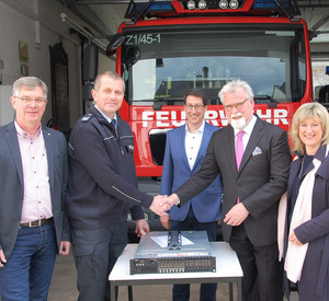 Gruppenfoto vor einem Feuerwehrfahrzeug von Karlheinz Weis, Markus Hensler, Jürgen Hoffmann, Herbert Mertin und Anke Beilstein mit einem Server im Vordergrund