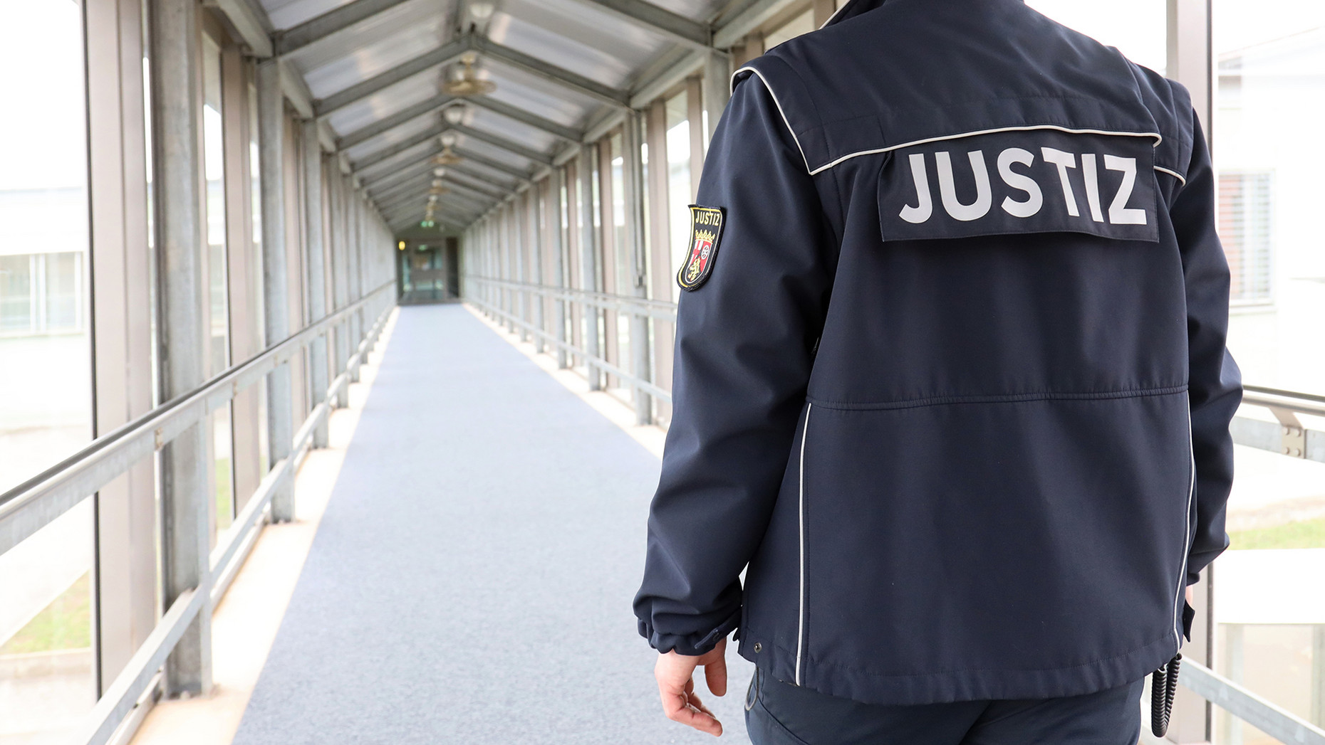 Justizvollzugsbeamter läuft über den Flur der JVA