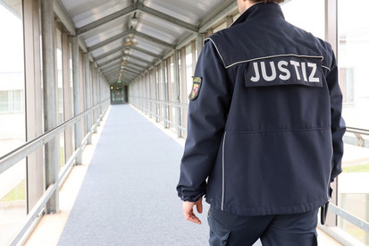 Justizvollzugsbeamter läuft über den Flur der JVA